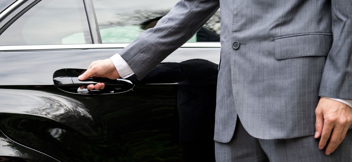 Man in business suit opening car door